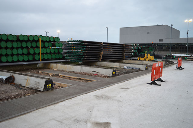diagonal view of long metal coils preparing to be transported outside factory